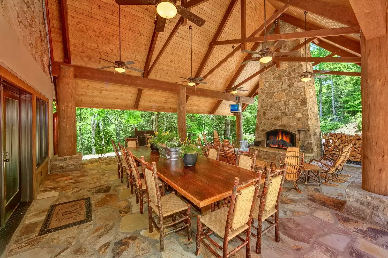 covered patio at Roosevelt Lodge cabin with dining tables and stone fireplace
