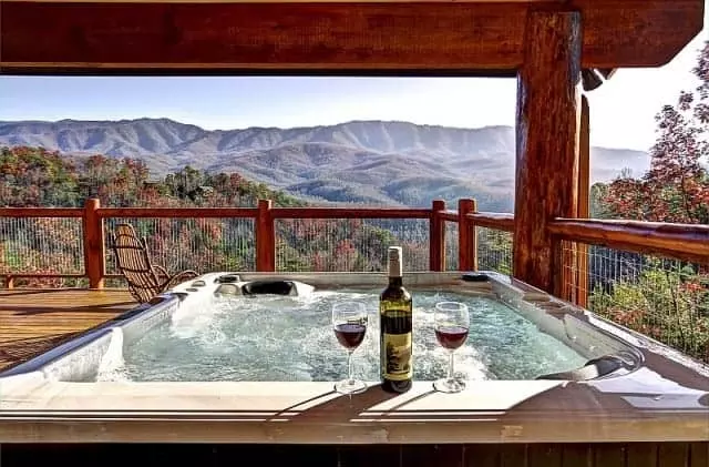 a hot tub on the deck of a cabin overlooking the Smoky Mountains