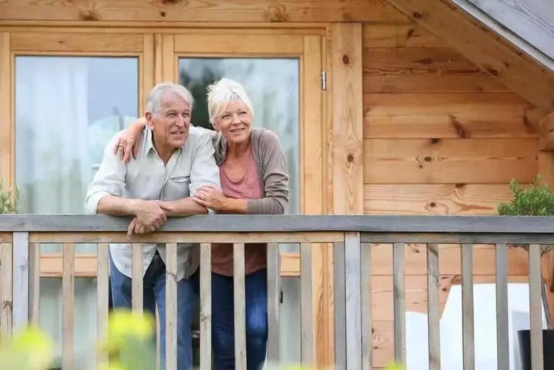 Older couple on the porch of their cabin