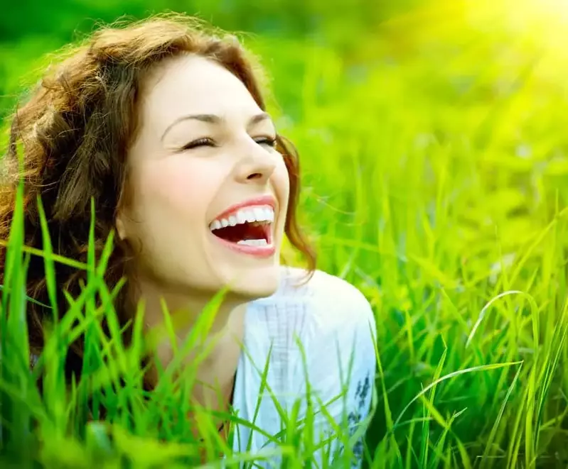 Happy woman smiling in a green field