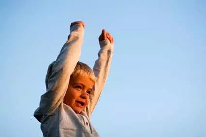 happy child raising arms in the air