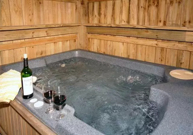 Glasses of wine sitting next to a hot tub in a Gatlinburg cabin