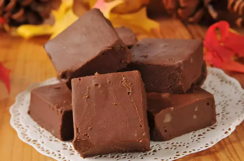 Chocolate fudge on a doily on a wood table