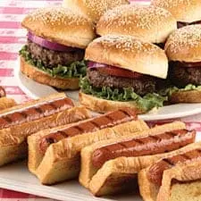 hamburgers and hot dogs on a red and white tablecloth