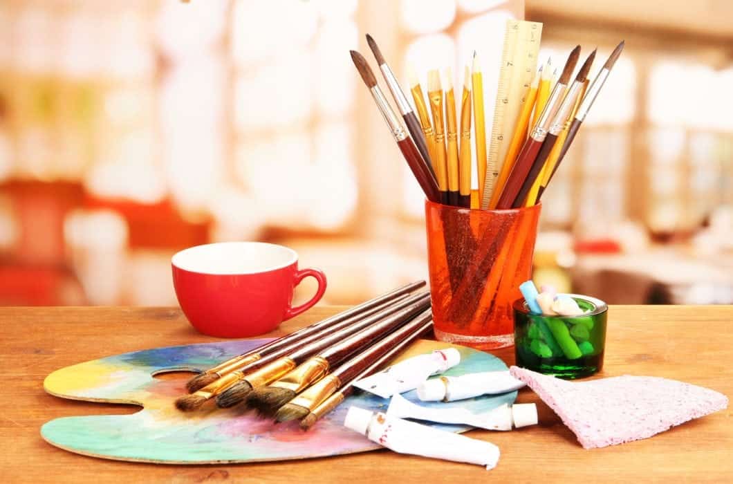 Paint brushes and palette on a table in an art studio