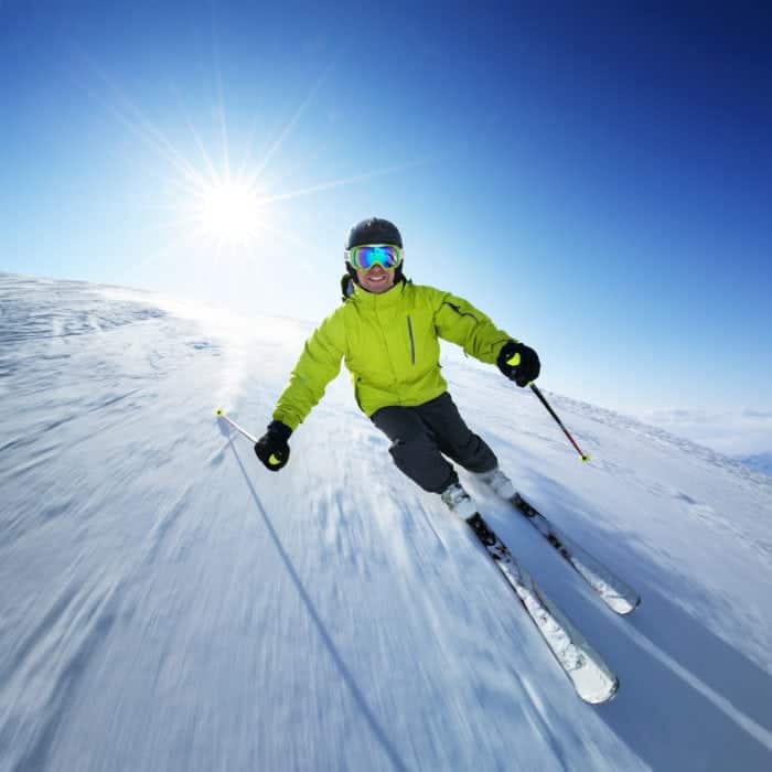 Man skiing down a mountain in the sunshine