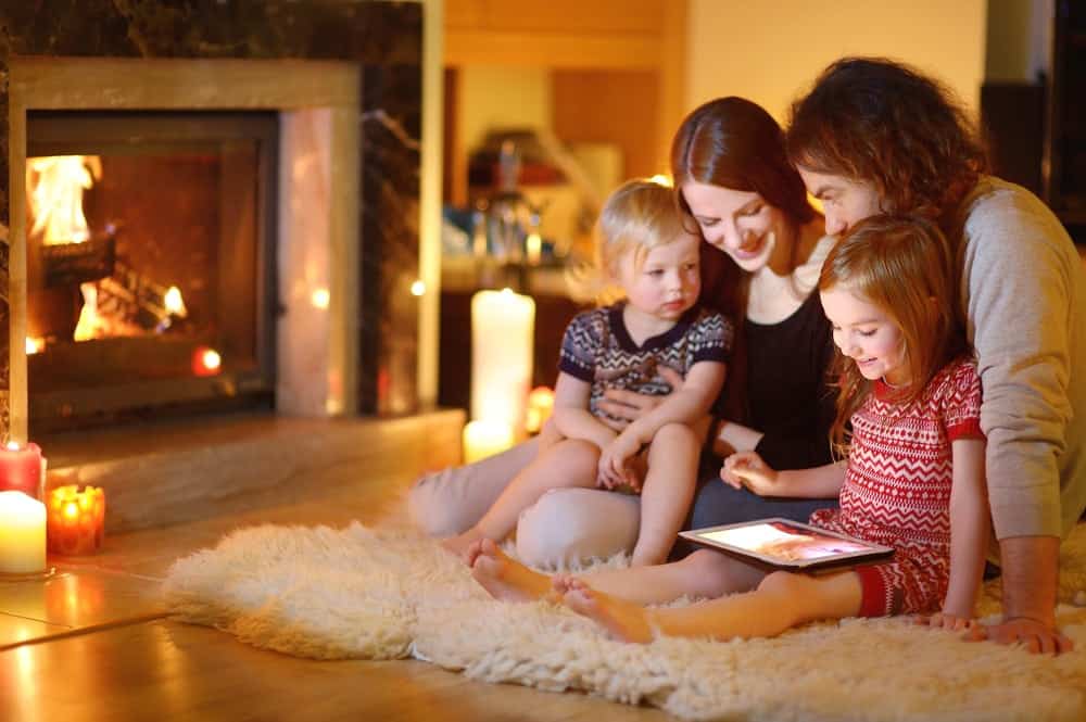 Family using a tablet by the fireplace in a Gatlinburg cabin