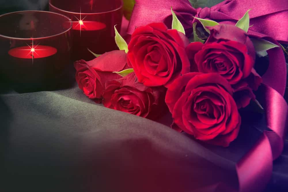 red roses and red candles on black cloth