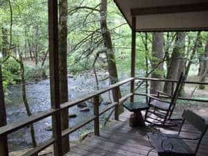 chairs and table on a cabin deck overlooking a river near Gatlinburg TN